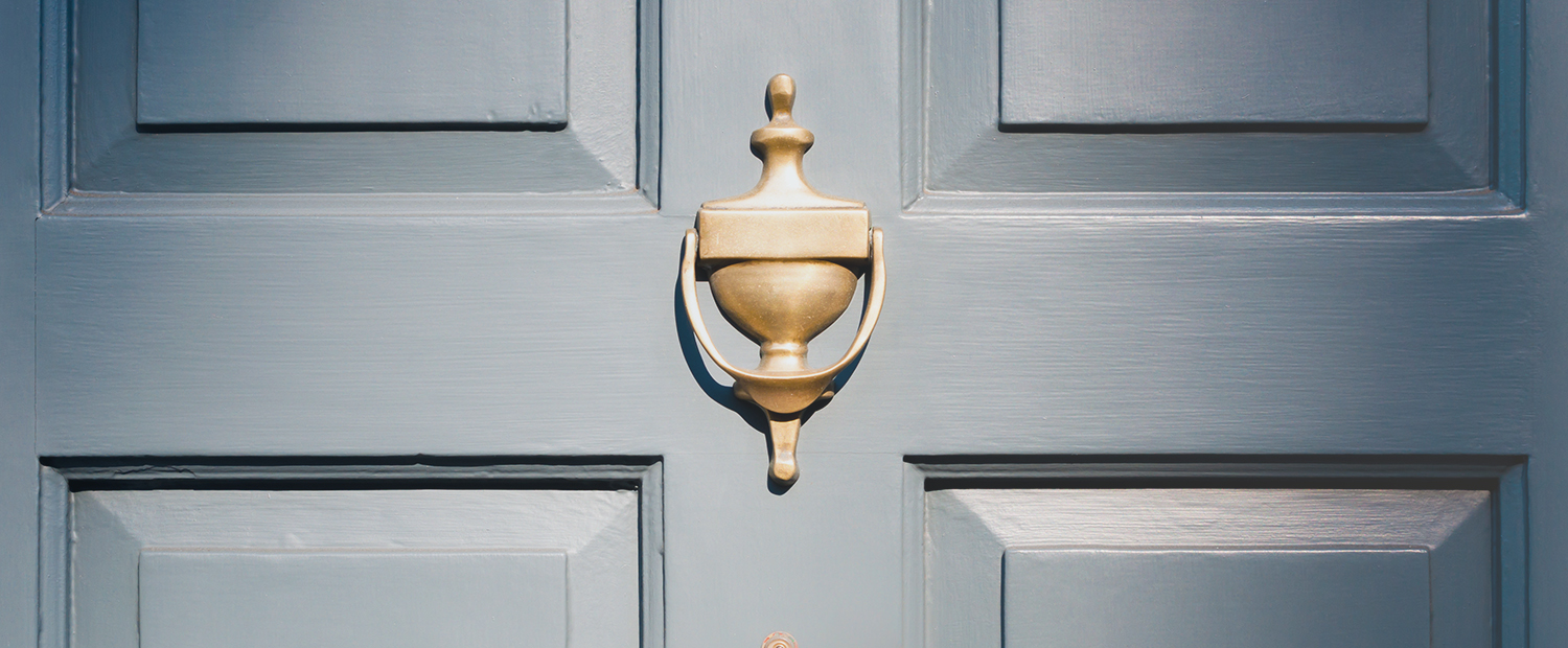 Background of vintage blue painted door and knocker vignette look
